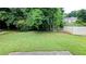 Spacious backyard featuring a large lawn area, mature trees, and privacy fence at 2153 Pine View Trl, Ellenwood, GA 30294