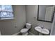 Powder room features a decorative mirror, pedestal sink, toilet, and window with natural light at 2153 Pine View Trl, Ellenwood, GA 30294