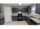 Modern kitchen featuring dark cabinets, stainless steel sink, and light granite countertops at 2153 Pine View Trl, Ellenwood, GA 30294
