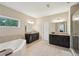 This bathroom offers double sinks with dark wood cabinets, a soaking tub, tiled floors, and a glass shower stall at 251 Parc Dr, Canton, GA 30114
