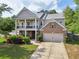 Charming two-story home with a welcoming front porch, landscaped yard, and attached two-car garage at 251 Parc Dr, Canton, GA 30114