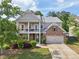 Charming two-story home with a brick and gray facade, complemented by a well-manicured lawn and inviting curb appeal at 251 Parc Dr, Canton, GA 30114