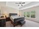 This main bedroom offers a tray ceiling with ceiling fan, neutral walls, carpet, and windows for ample natural light at 251 Parc Dr, Canton, GA 30114