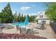 Relaxing community pool area with lounge chairs, tables, umbrellas, and lush landscaping at 251 Parc Dr, Canton, GA 30114