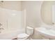 Bathroom with a white sink, matching toilet, and a tub with white tile surround at 3185 Highgreen Trl, Atlanta, GA 30349