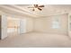 Spacious bedroom featuring a tray ceiling, ceiling fan, and neutral carpeting, ready for personalization at 3185 Highgreen Trl, Atlanta, GA 30349