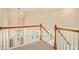 Second story landing with wooden railing, plush carpet, and decorative light fixture at 3185 Highgreen Trl, Atlanta, GA 30349