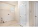 Functional laundry room features tile flooring, a utility sink, and shelving for convenient organization at 3185 Highgreen Trl, Atlanta, GA 30349