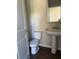 Cozy half bathroom with a pedestal sink, toilet, and shiplap door at 4287 Traipse Path, Ellenwood, GA 30294