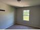 Bedroom with neutral-colored walls, carpeted flooring, a window, and a ceiling light fixture at 4287 Traipse Path, Ellenwood, GA 30294