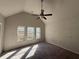 Well-lit bedroom with vaulted ceiling, ceiling fan, carpeted floors, and three large windows at 4287 Traipse Path, Ellenwood, GA 30294