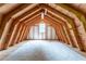 A large attic space featuring exposed wooden beams and a small window for natural light at 1652 Weymouth Ct, Tucker, GA 30084