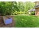 Large grassy backyard with garden bed and mature trees and shrubs at 1652 Weymouth Ct, Tucker, GA 30084