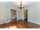 Open dining room with hardwood floors, a chandelier, and glass doors leading to other rooms at 1652 Weymouth Ct, Tucker, GA 30084