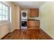 Bright laundry room with wooden cabinets, granite countertop, and a stacked washer and dryer at 1652 Weymouth Ct, Tucker, GA 30084