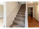 Carpeted staircase featuring white handrails and access to upper levels at 1652 Weymouth Ct, Tucker, GA 30084