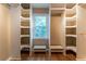 Bright walk-in closet featuring a window and custom shelving with hardwood flooring at 1652 Weymouth Ct, Tucker, GA 30084