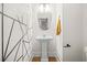 Small powder room features pedestal sink, decorative wallpaper and unique oval mirror at 2744 Bell Se Dr, Smyrna, GA 30080