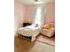 Bright bedroom featuring a white metal bed frame, cozy armchair and pink walls at 2945 Dogwood Creek Parkway, Duluth, GA 30096