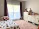 Cozy bedroom with plush pink rug, comfy bed and bright natural light shining through the large window at 2945 Dogwood Creek Parkway, Duluth, GA 30096