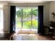 Living room featuring a large window and dark curtains with a view of the backyard at 2945 Dogwood Creek Parkway, Duluth, GA 30096