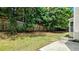 Fenced backyard with trees providing shade and a concrete patio area, perfect for outdoor entertaining at 3881 Micah Ln, Ellenwood, GA 30294