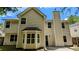 Two-story house with beige siding, a brick chimney, and a bay window, set against a blue sky at 3881 Micah Ln, Ellenwood, GA 30294