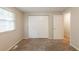 This bedroom has carpet floors, neutral walls and a double closet with natural light from a window at 5372 Martins Crossing Rd, Stone Mountain, GA 30088