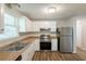 Updated kitchen with stainless steel appliances, wood look flooring, and ample counter space at 5372 Martins Crossing Rd, Stone Mountain, GA 30088