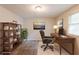 This staged office includes a work space, book shelf, office chair and natural light from the window at 5372 Martins Crossing Rd, Stone Mountain, GA 30088