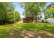 Expansive backyard with a charming home featuring a covered porch, wood accents, flowers, and mature trees at 638 Medford Se Pl, Smyrna, GA 30080