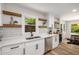 Bright kitchen featuring white countertops, stainless steel appliances, modern finishes, and floating shelves at 638 Medford Se Pl, Smyrna, GA 30080