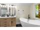 This main bathroom has a soaking tub, natural light, and wooden cabinets at 638 Medford Se Pl, Smyrna, GA 30080