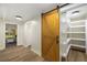 Bright pantry with wood-look floors, custom wooden barn door, and lots of open shelving and storage space at 638 Medford Se Pl, Smyrna, GA 30080