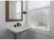 Chic powder room featuring a pedestal sink, framed mirror, and plantation shutters at 808 Angora Aly, Scottdale, GA 30079