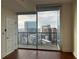 Bedroom showing floor to ceiling windows with a balcony, and views of city buildings at 1080 Peachtree Ne St # 2915, Atlanta, GA 30309