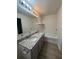 Bathroom featuring double sinks with granite counters, wood look floors and tub with shower at 1700 Devon Sw Dr, Atlanta, GA 30311