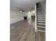 Open-concept living room with fireplace, stairs, and wood-look flooring at 1700 Devon Sw Dr, Atlanta, GA 30311