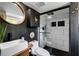 Modern bathroom featuring a black framed shower, vanity with vessel sink, and a round mirror at 445 Brownell Ave, Scottdale, GA 30079