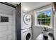 Efficient laundry area with stacked washer and dryer next to a window at 445 Brownell Ave, Scottdale, GA 30079