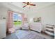 Bright Bedroom with a large window, a crib, neutral tones, and pink and white décor at 829 Christopher Rd, Sharpsburg, GA 30277
