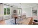 Sun-drenched dining room featuring large windows, elegant chandelier, and seating for eight at 829 Christopher Rd, Sharpsburg, GA 30277