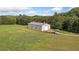 Large metal outbuilding on vast green lawn with surrounding woods at 829 Christopher Rd, Sharpsburg, GA 30277