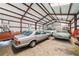 Spacious metal outbuilding interior with concrete floor, multiple vehicles, and ample storage space at 829 Christopher Rd, Sharpsburg, GA 30277