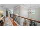 Bright hallway with hardwood floors, decorative wrought iron railing, and elegant chandelier at 829 Christopher Rd, Sharpsburg, GA 30277