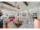 Open concept living room showcasing beamed ceilings, a fireplace, hardwood flooring, and stylish furnishings at 829 Christopher Rd, Sharpsburg, GA 30277
