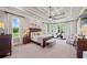 Spacious primary bedroom featuring a tray ceiling, large windows, and a seating area at 829 Christopher Rd, Sharpsburg, GA 30277