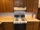 Retro kitchen with wooden cabinets, faux marble walls, vintage stove with burner top, and tiled backsplash at 286 Toweridge Sw Dr # 3, Marietta, GA 30064