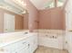 Bright bathroom featuring a double sink vanity, a soaking tub, and tiled accents at 421 Old Ivy Path, Mcdonough, GA 30253