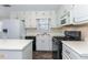Well-lit kitchen features white cabinets, modern appliances, and a functional layout for easy meal preparation at 421 Old Ivy Path, Mcdonough, GA 30253